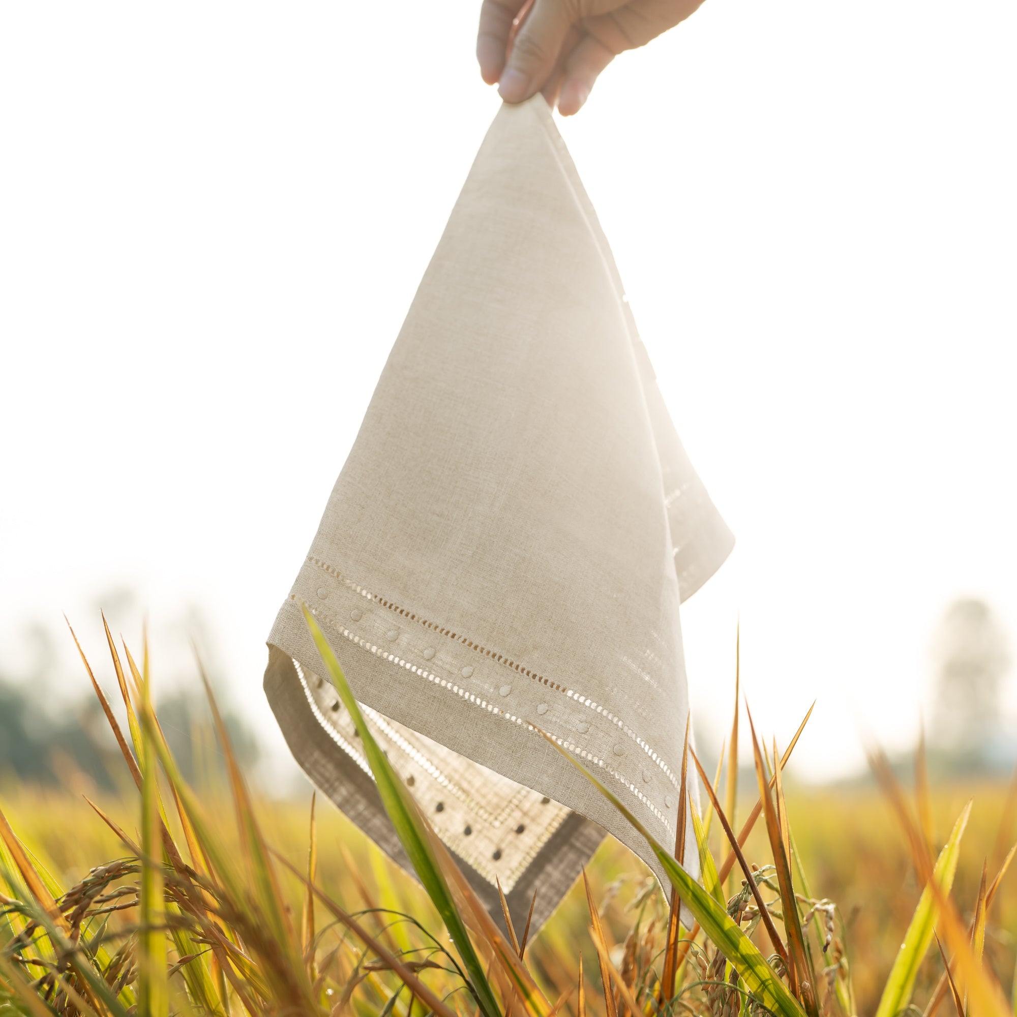 Detail of Double Hemstich Swiss Dot Napkin as it is draped by hand in rice field
